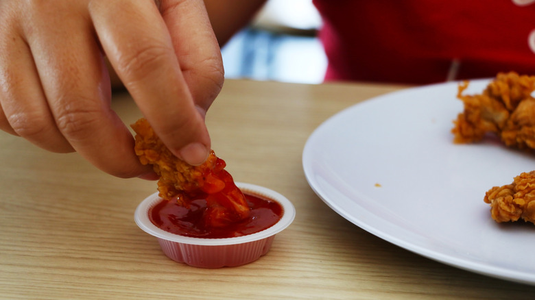 Hand dipping in sauce