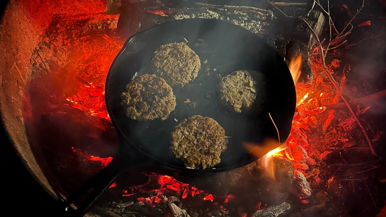 burger patties cooking in cast iron