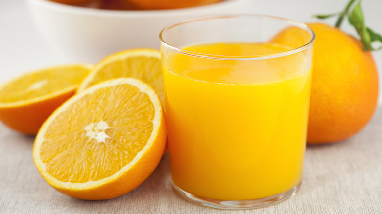 cup of juice and oranges