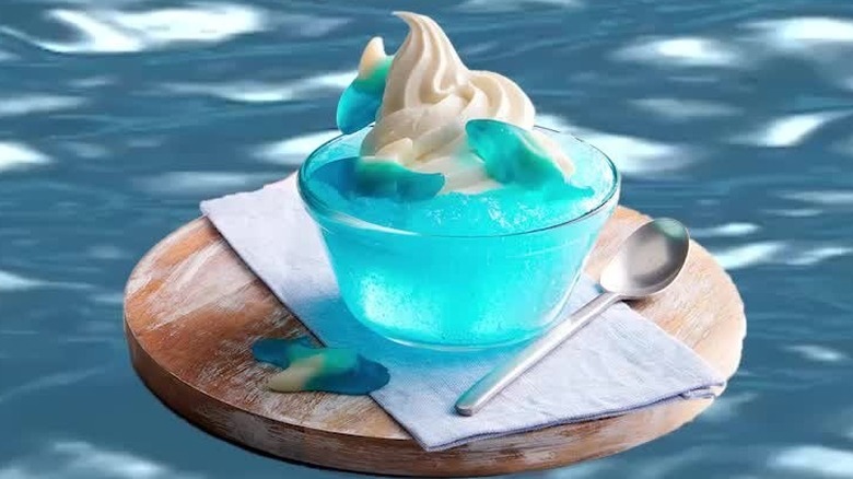 Close up of Shark Bait Flavored ICEE dessert floating in water with shark gummies and ice cream on top