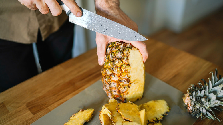 Man cutting a pineapple