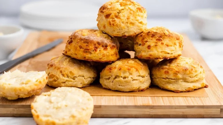 pile of cheese biscuits on cutting board with knife