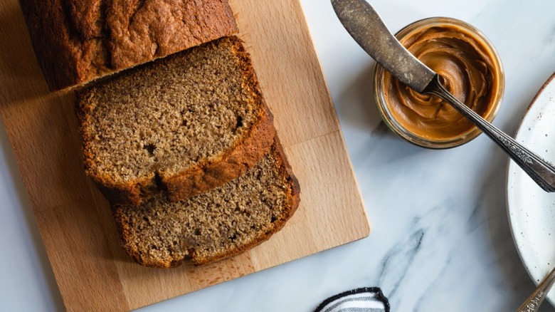 cookie butter banana bread on wooden board with cookie butter jar and knife