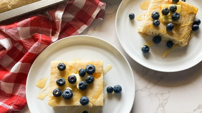 plates of sheet pan pancakes with blueberries and red checkered towel