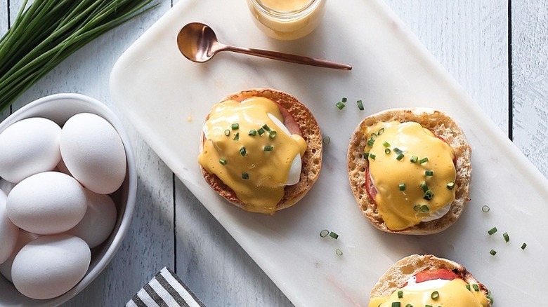 plate of eggs benedict with hollandaise and chives