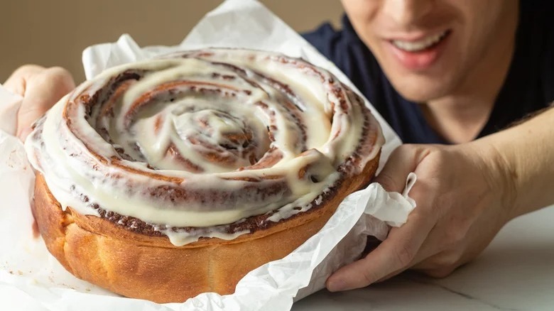 person holding giant cinnamon roll