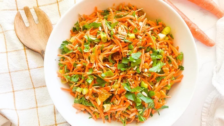 bowl of moroccan carrot salad with wooden spoon