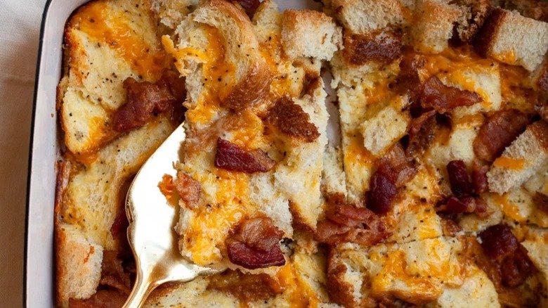 dish of overnight breakfast casserole with bacon serving spoon
