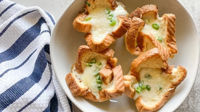 plate of baked eggs in a basket with dish towel