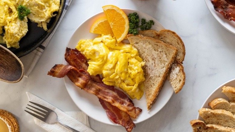plate of scrambled eggs with toast bacon garnish
