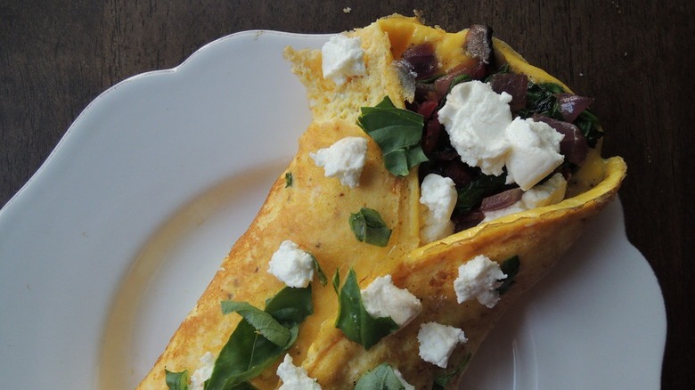 plate with veggie omelet topped with goat cheese