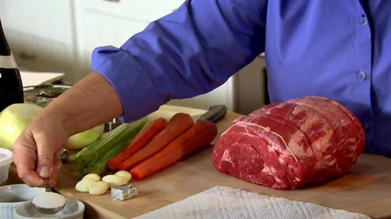 adding seasoning to pot roast