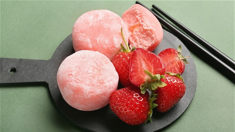 Plate of pink mochis and strawberries 