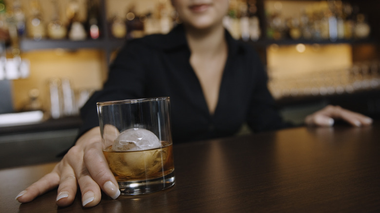 Woman holds whiskey glass