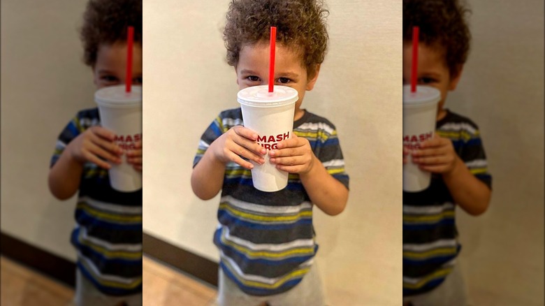 child holding smashburger drink