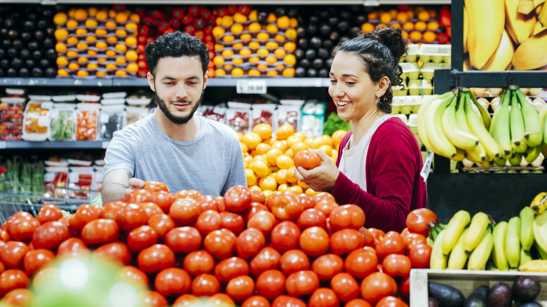 people grocery shopping for tomatoes