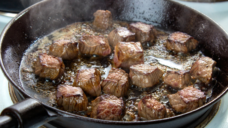 Searing chunks of beef