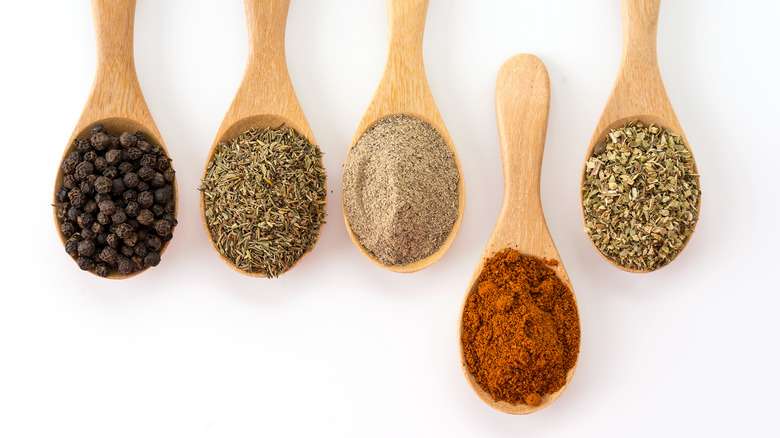 Different spices on wooden spoons