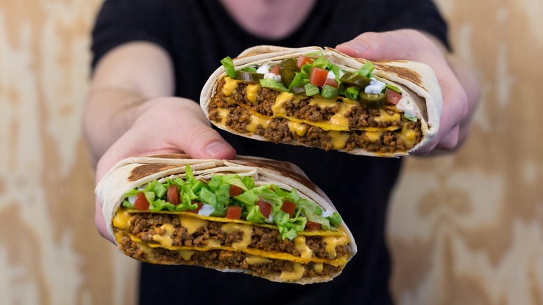 man holding two Triple Double Crunchwraps