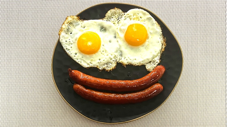 Plate of sunny side eggs with sausage links