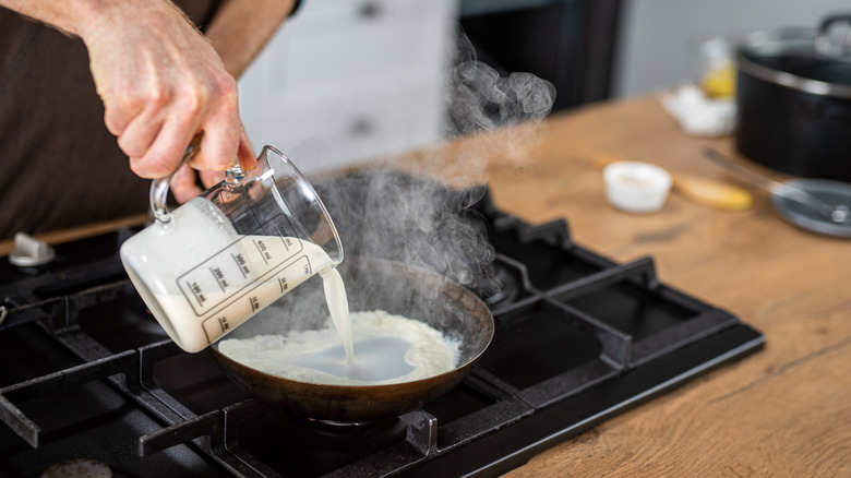 pouring cream into frying pan