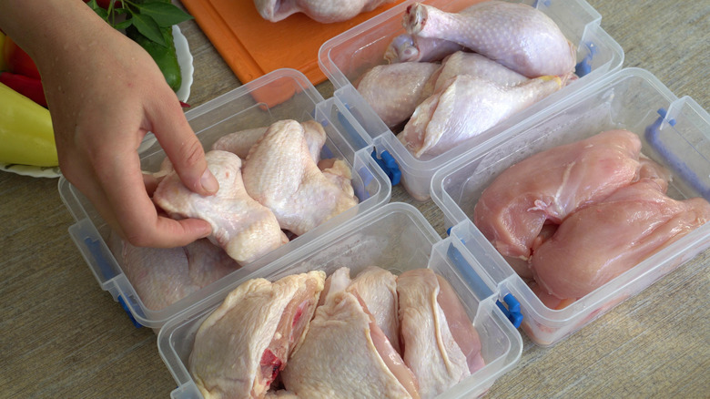 portioning out raw chicken in containers