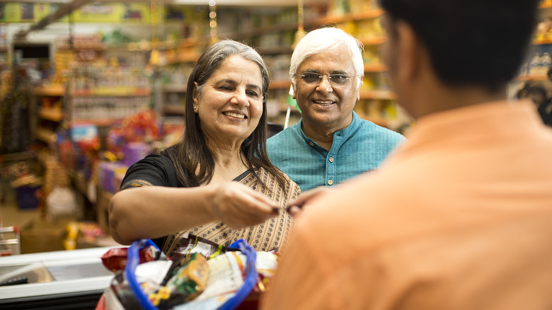 people paying at grocery store checkout