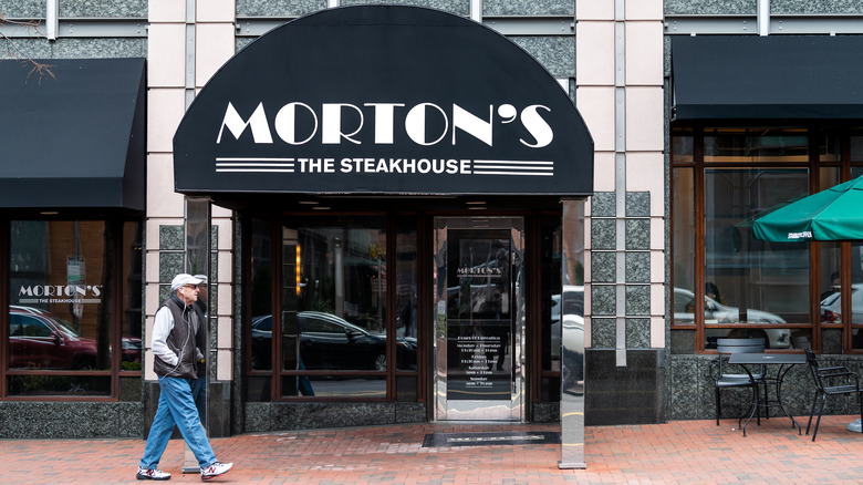 man walking past morton's steakhouse