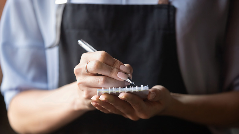 Barista writing notes