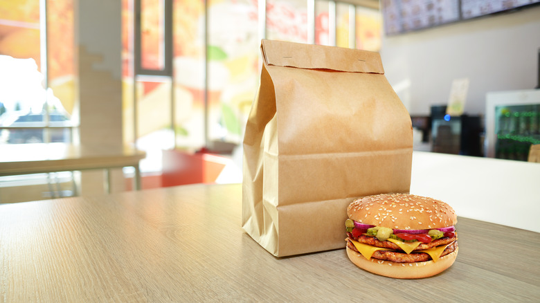 burger on table with brown bag