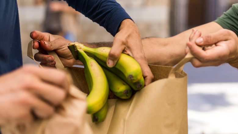 Placing bananas in paper bag