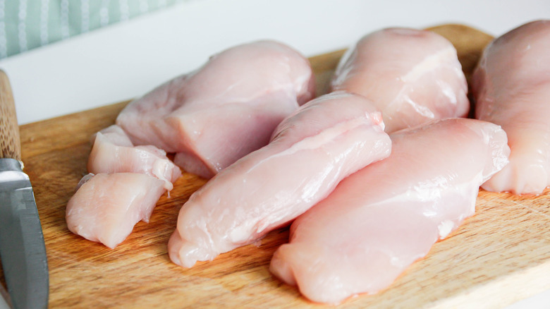 Raw chicken breasts on cutting board