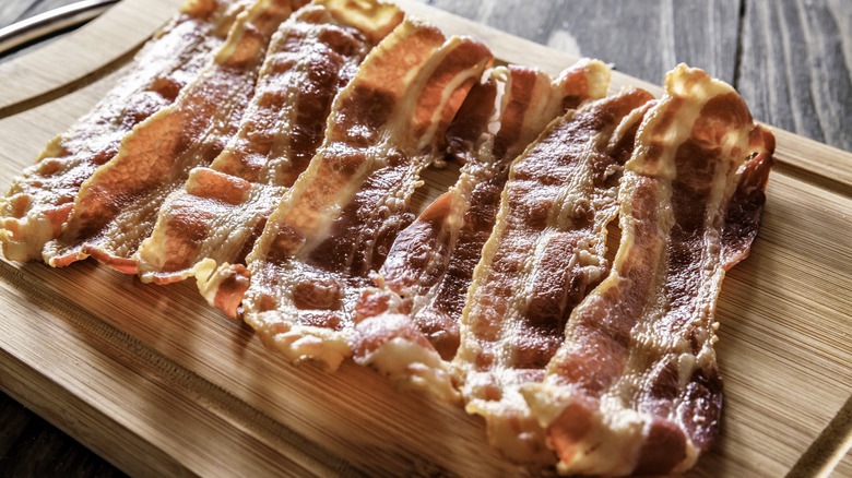 cooked bacon on cutting board