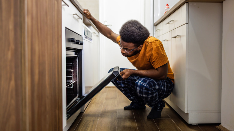 man looking inside the oven