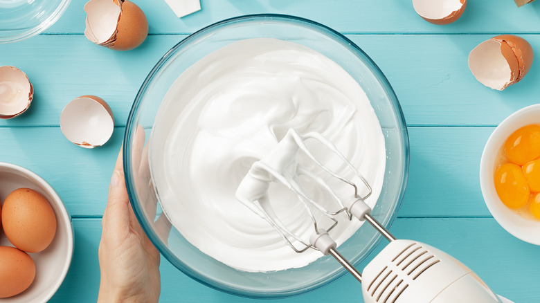 whipping meringue in glass bowl