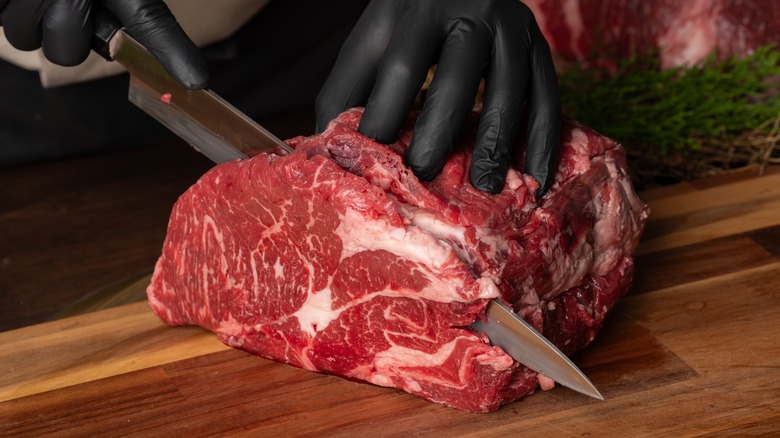 Person cutting raw meat