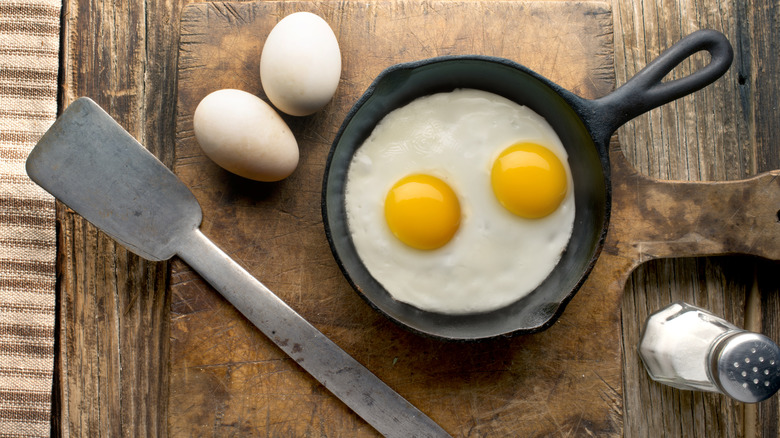 fried egg in pan with salt shaker