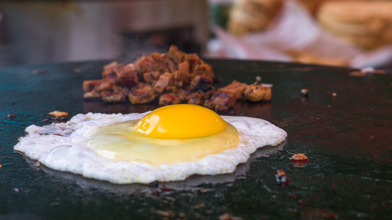 restaurant cooking a fried egg on a griddle