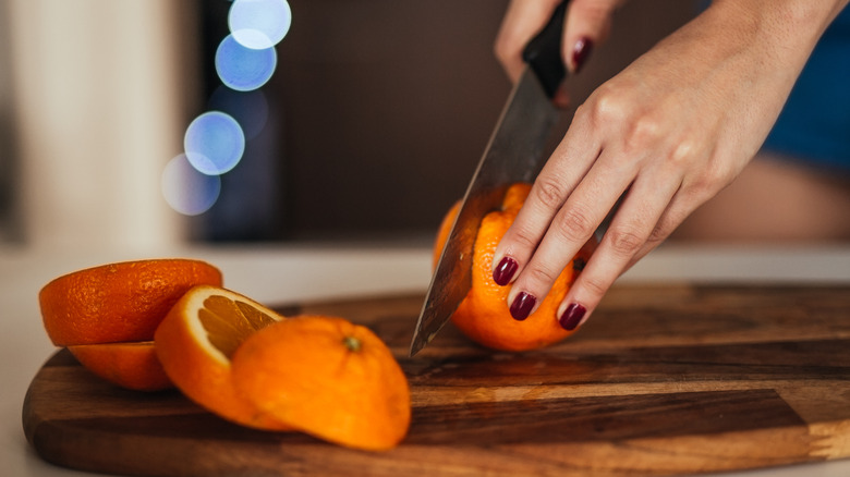 woman hands slicing oranges