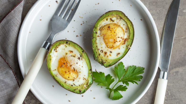 plate of baked eggs in avocado