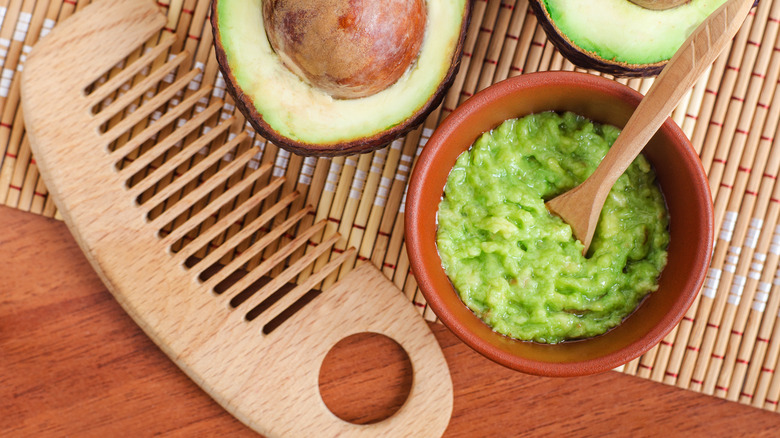 bowl of mashed avocado and hairbrush