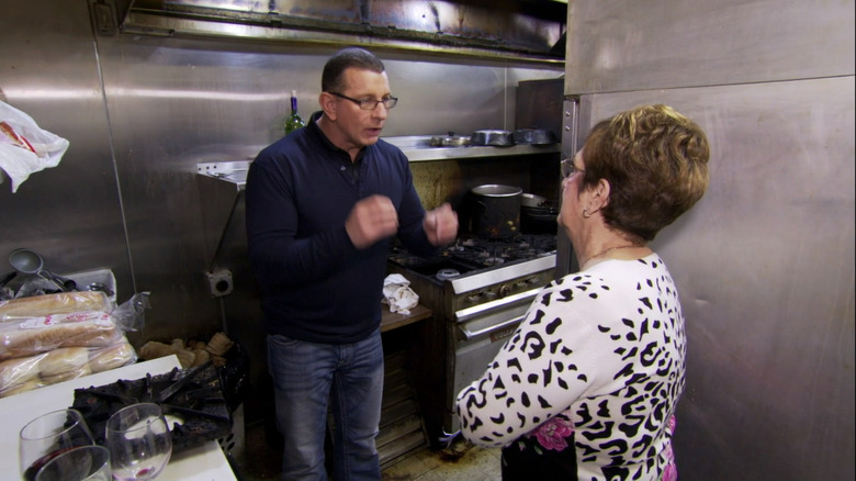 Robert Irvine speaking with a restaurant owner in a dirty kitchen