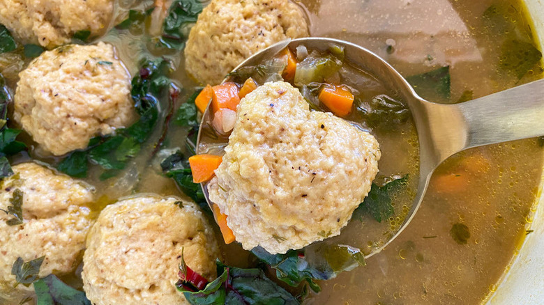 Bowl of matzo ball soup with greens