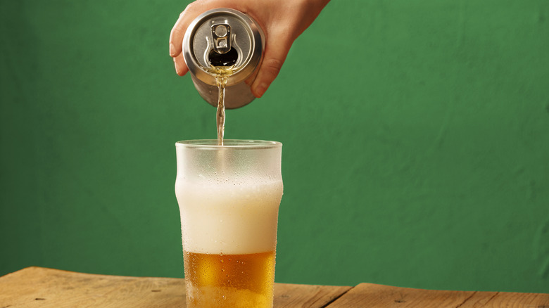 pouring beer from can into glass