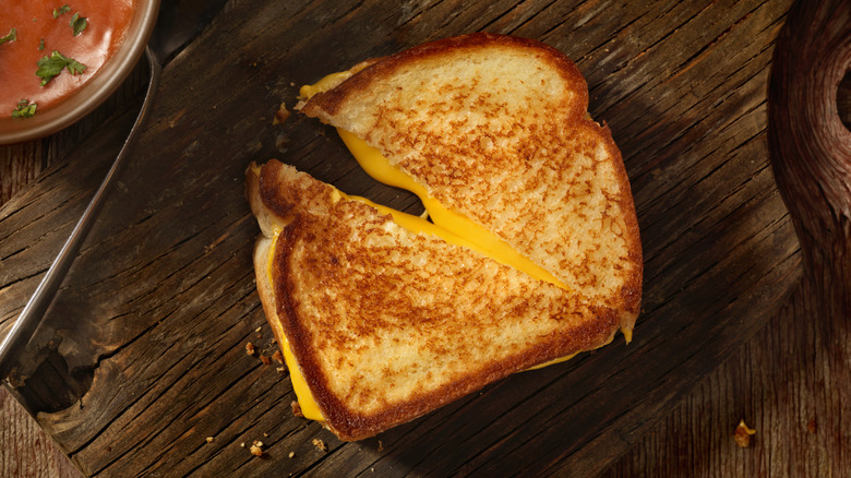 Sliced grilled cheese on wooden board