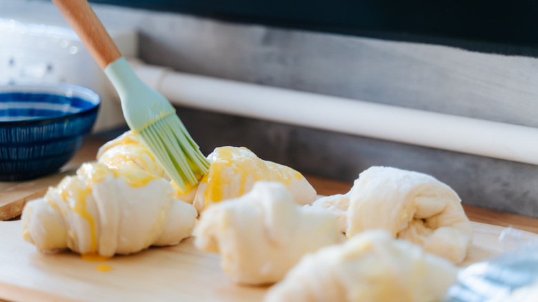 brushing egg on croissant