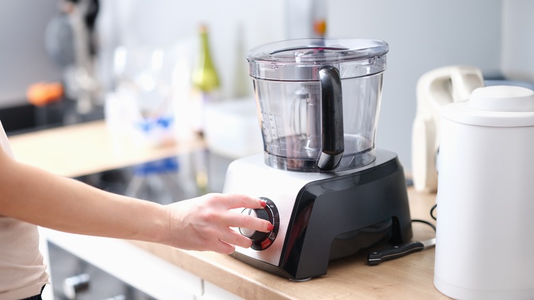 Woman turns on food processor