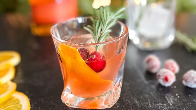 Cocktail with orange, cranberries, and rosemary