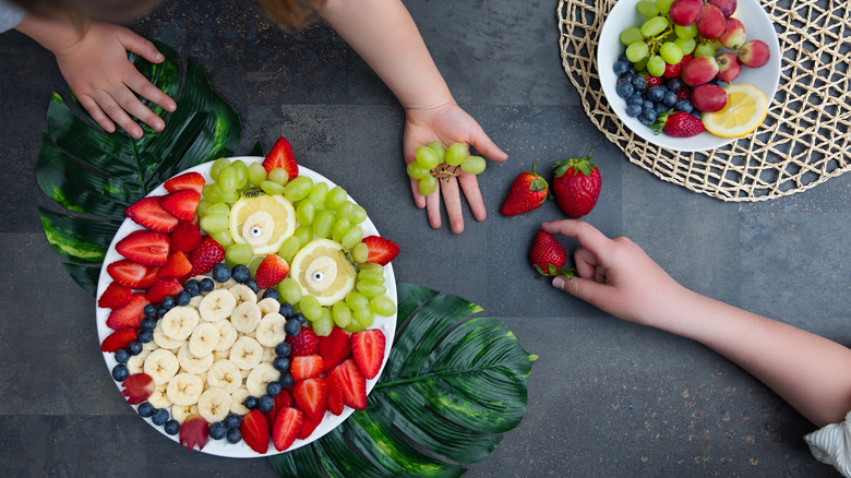 fruit platter with kids reaching in