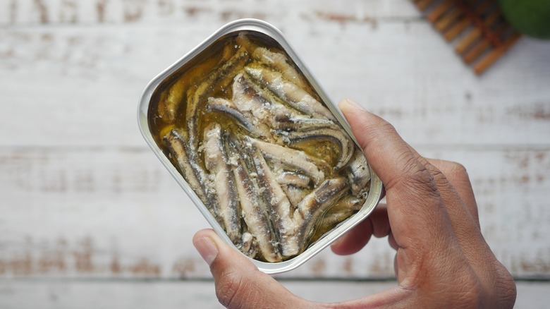 hand holding can of sardines